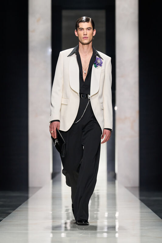 Элегантный образ в белом пиджаке с черным воротником, черная рубашка и стильные аксессуары создают атмосферу утонченности