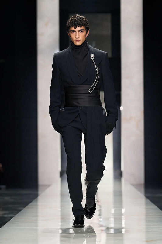 Элегантный черный наряд с акцентом на пояс и блестящей брошью, подчеркивающий силуэт и стиль