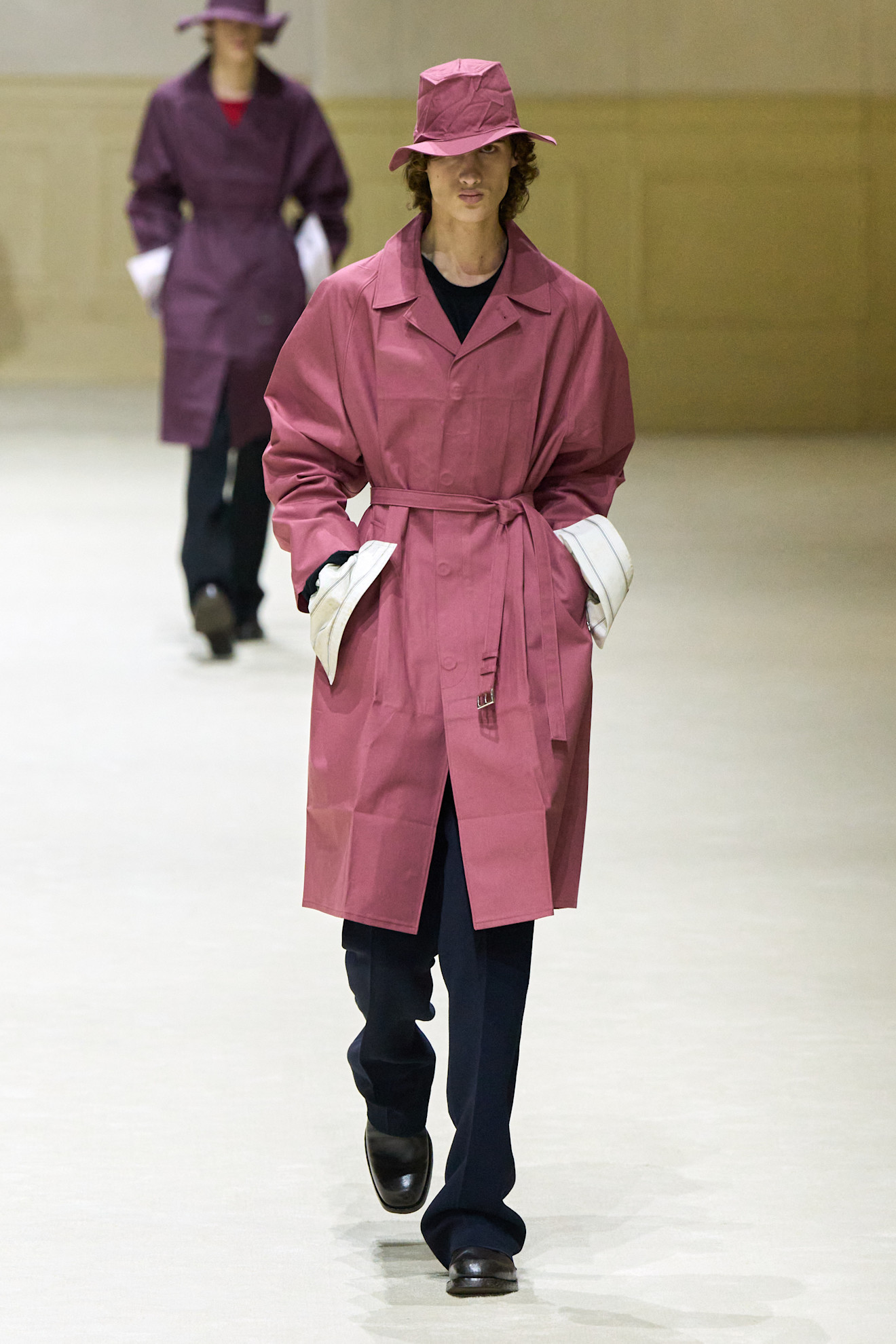 Парень в розовом тренче и шляпе, с контрастными белыми манжетами, создает яркий и запоминающийся образ