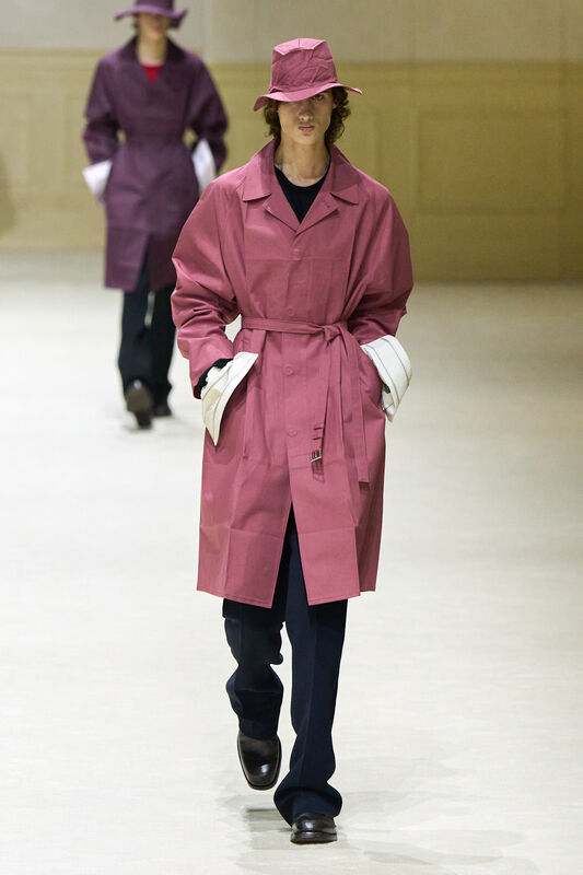 Парень в розовом тренче и шляпе, с контрастными белыми манжетами, создает яркий и запоминающийся образ