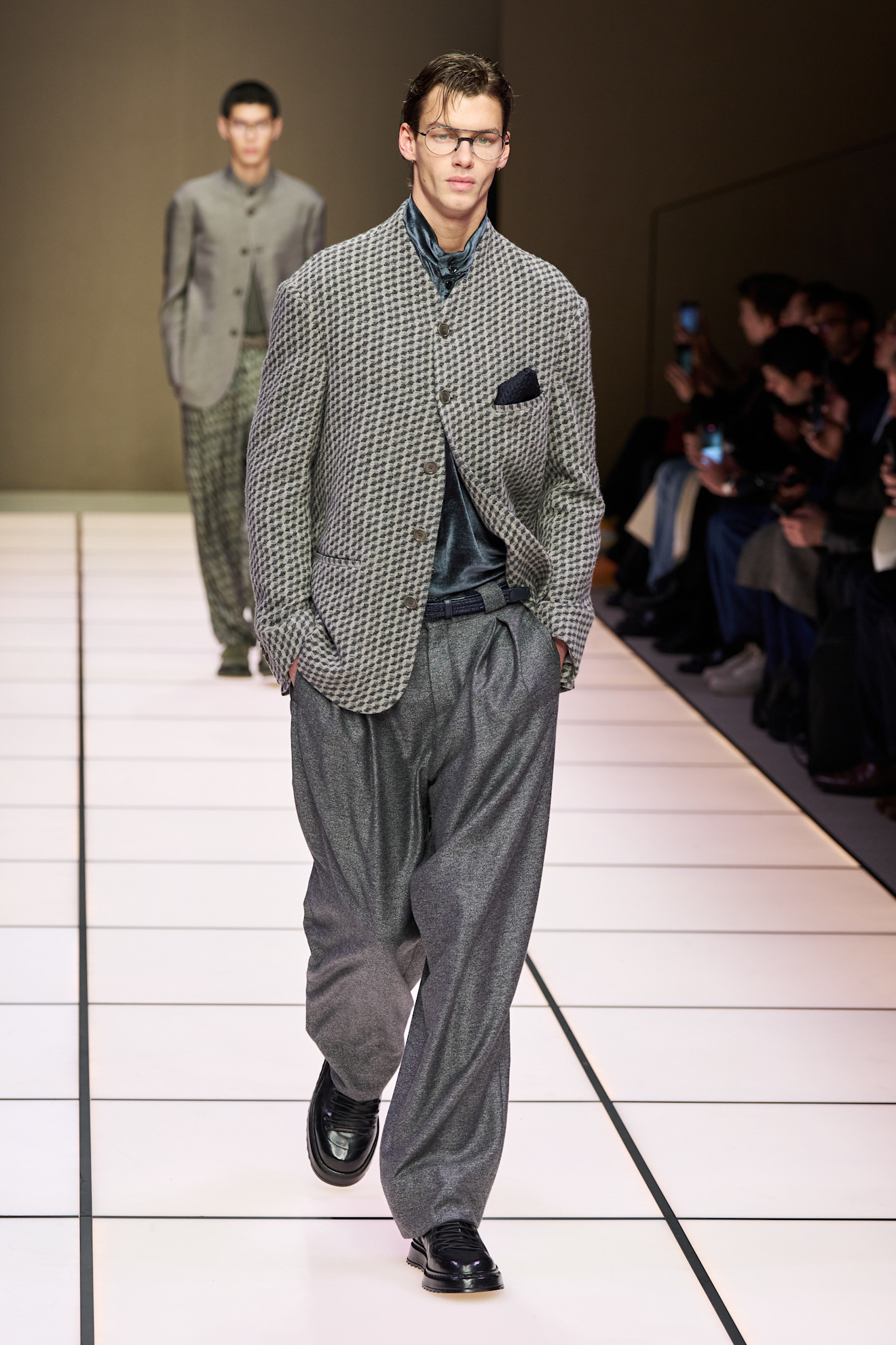 Модель в клетчатом пиджаке и широких брюках, создающих эффектный силуэт, демонстрирует утонченность коллекции Armani