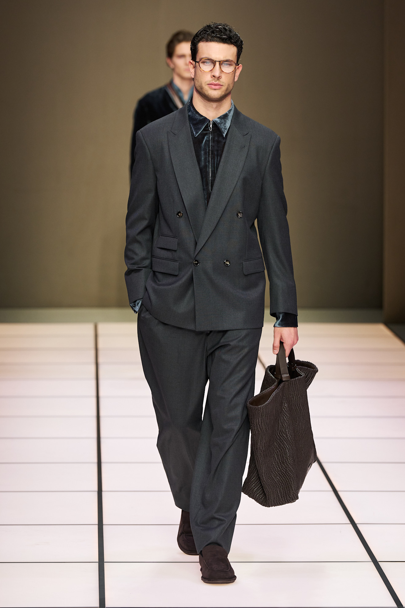Элегантный мужской костюм в темно-сером цвете с двойным пиджаком и текстурированной сумкой, создающий стильный образ для осени