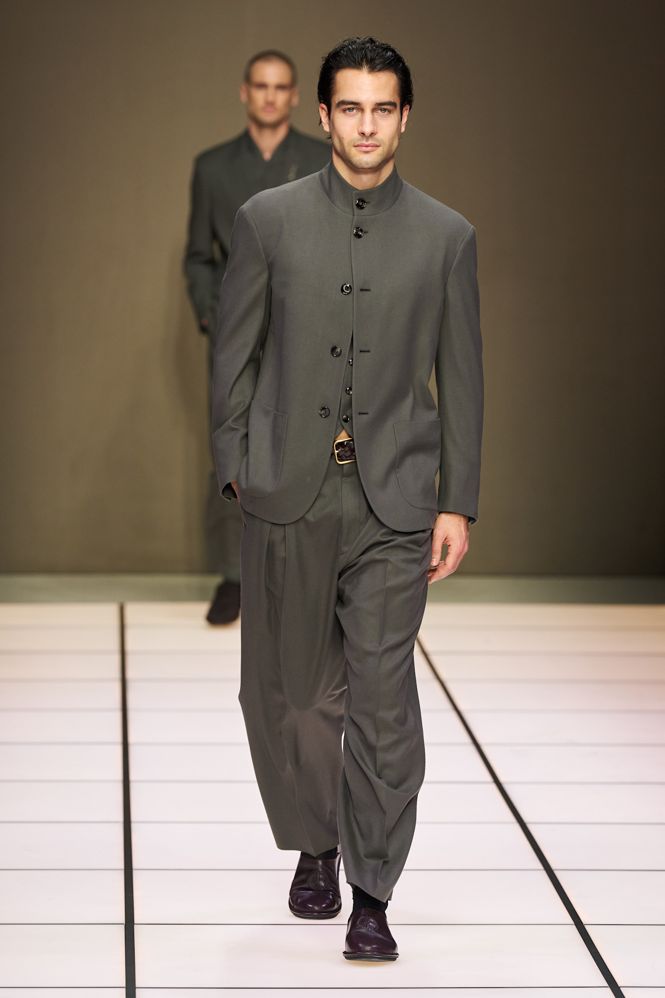 Минималистичный костюм серого цвета с высоким воротником и широкими брюками, отражающий сдержанную элегантность осеннего сезона