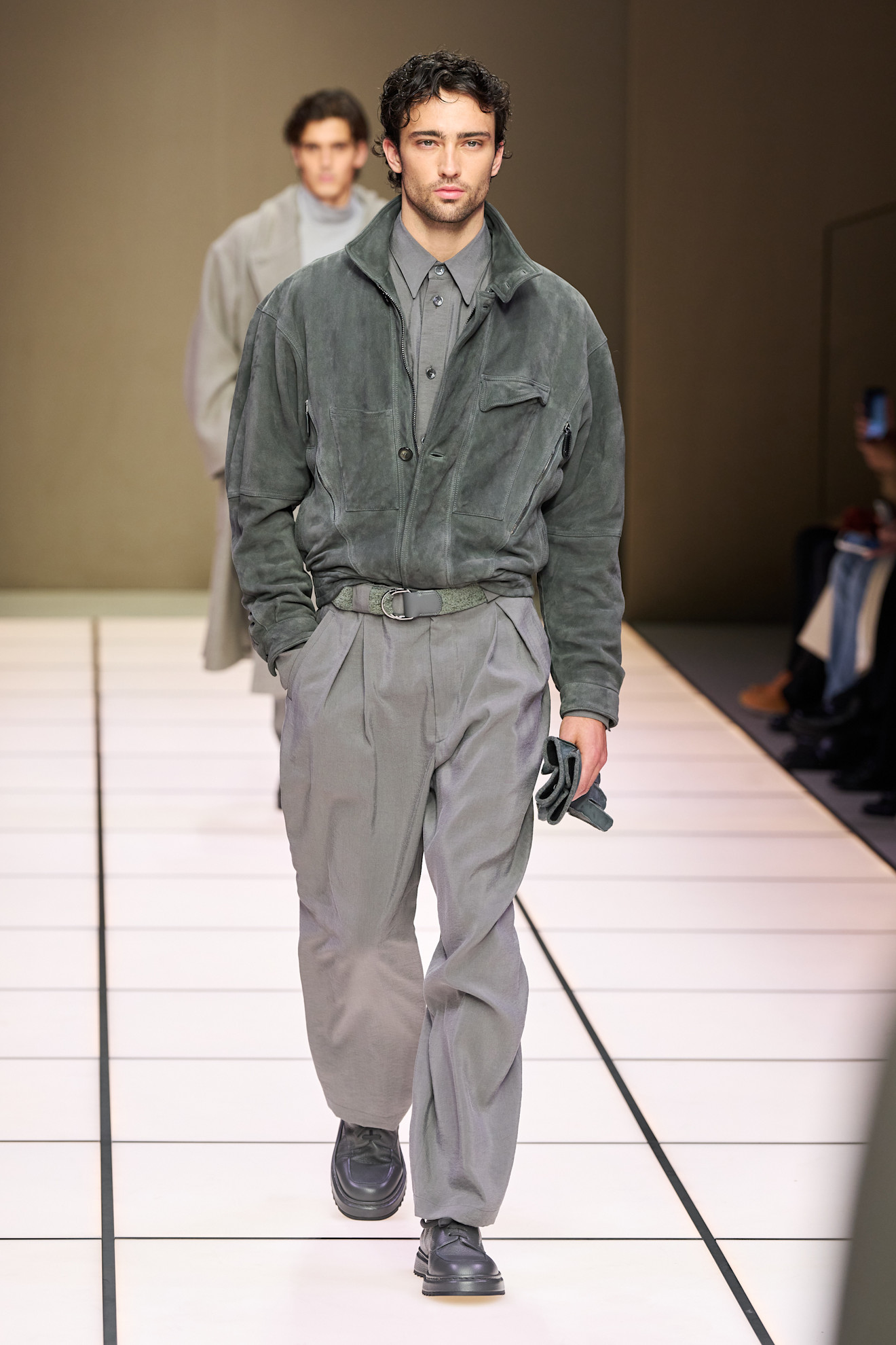 Мужская модель в мягком сером замшевом куртке и брюках, гармонирующих по цвету, с акцентом на стильные детали