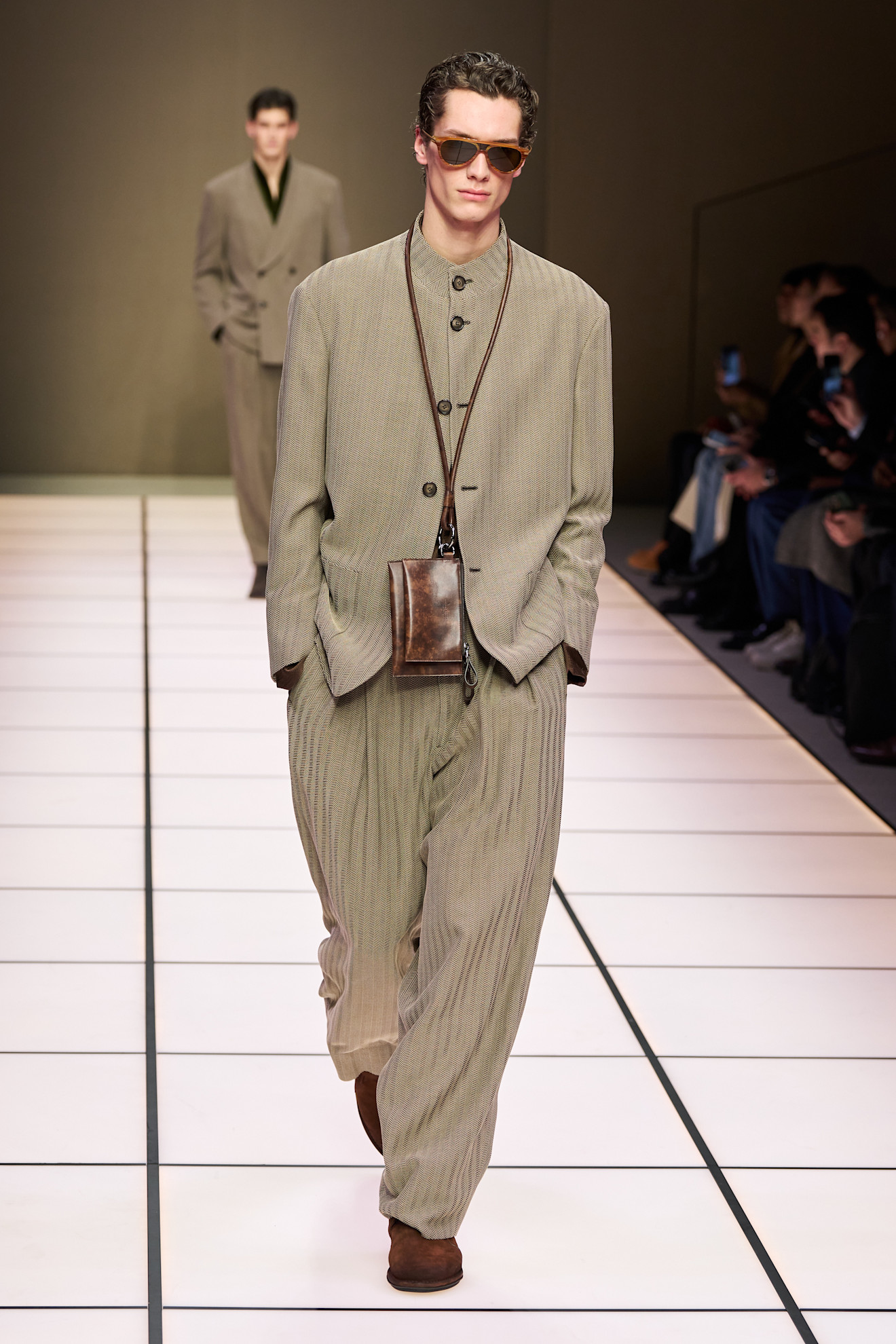 Образ с рельефным жакетом и широкими брюками, дополненный кожаной сумкой, подчеркивает современный минимализм