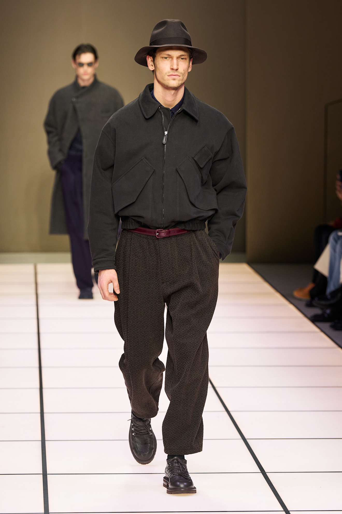 Стильный черный жакет с широкими карманами и брюки с узором, дополненные элегантной шляпой для завершения образа