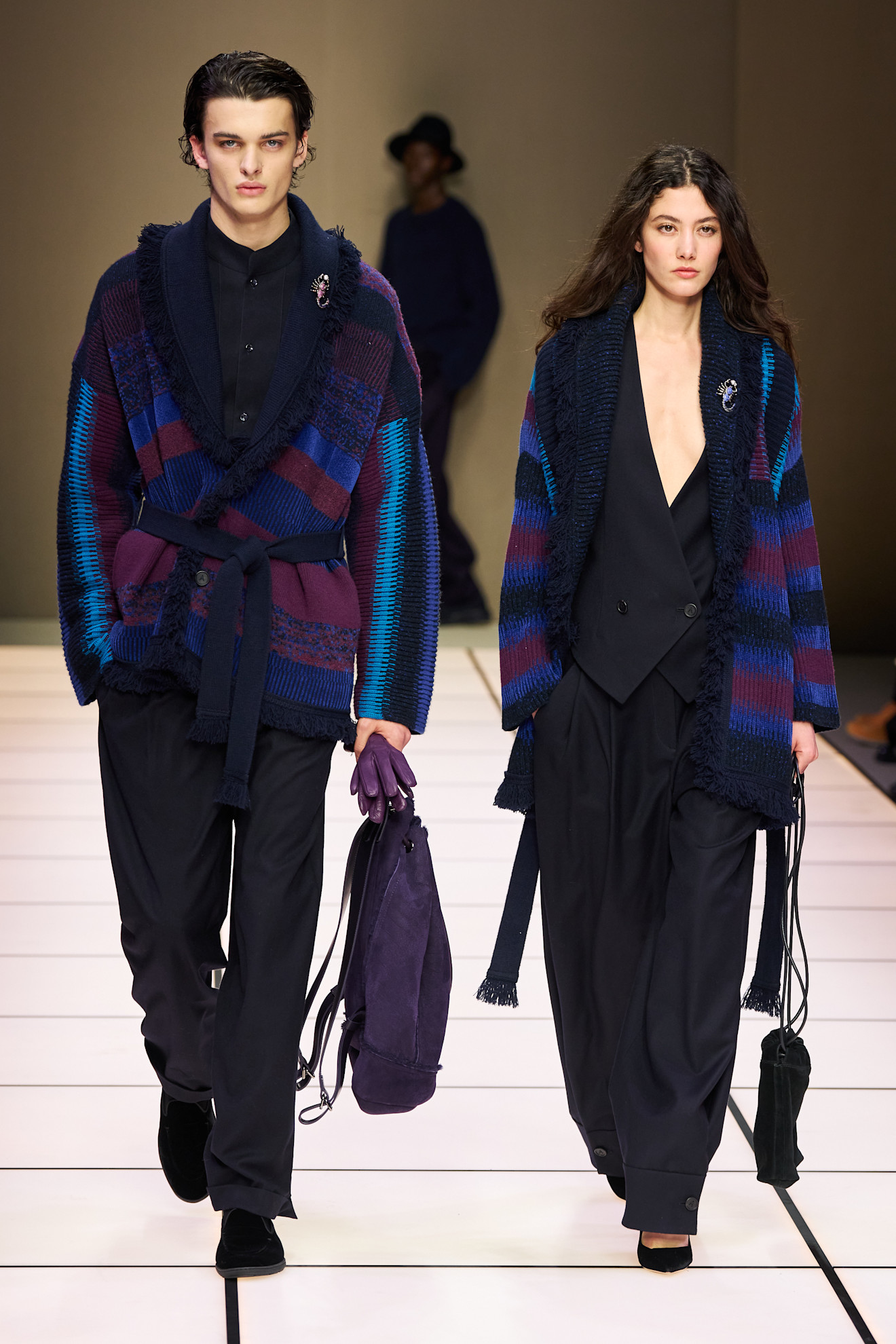 Два манекенщика в ярких кардиганах с геометрическим узором, один из них с сумкой, создают стильный дуэт