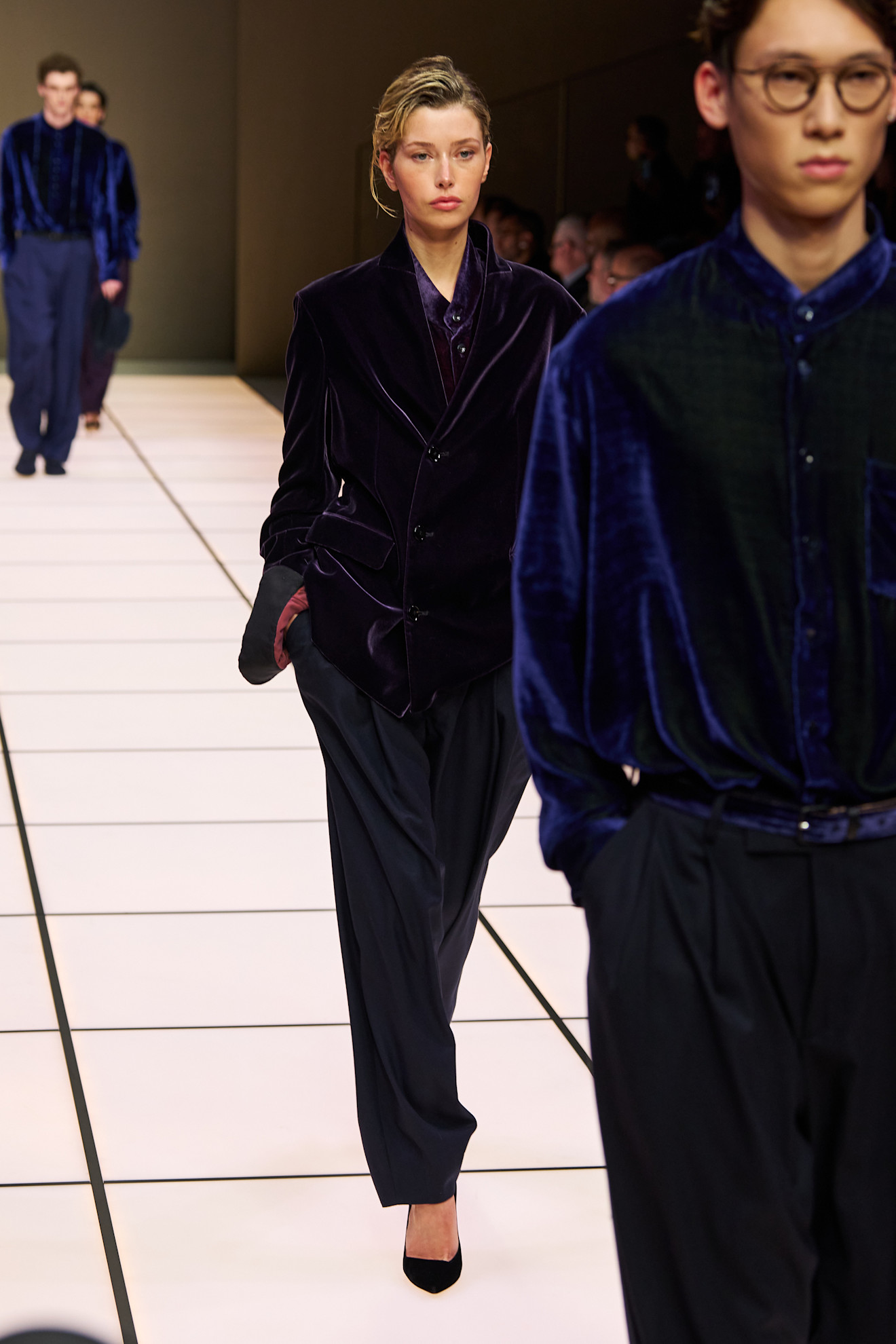 Женская модель в темно-синем бархатном пиджаке и брюках, с легкой небрежностью, подчеркивающей стиль