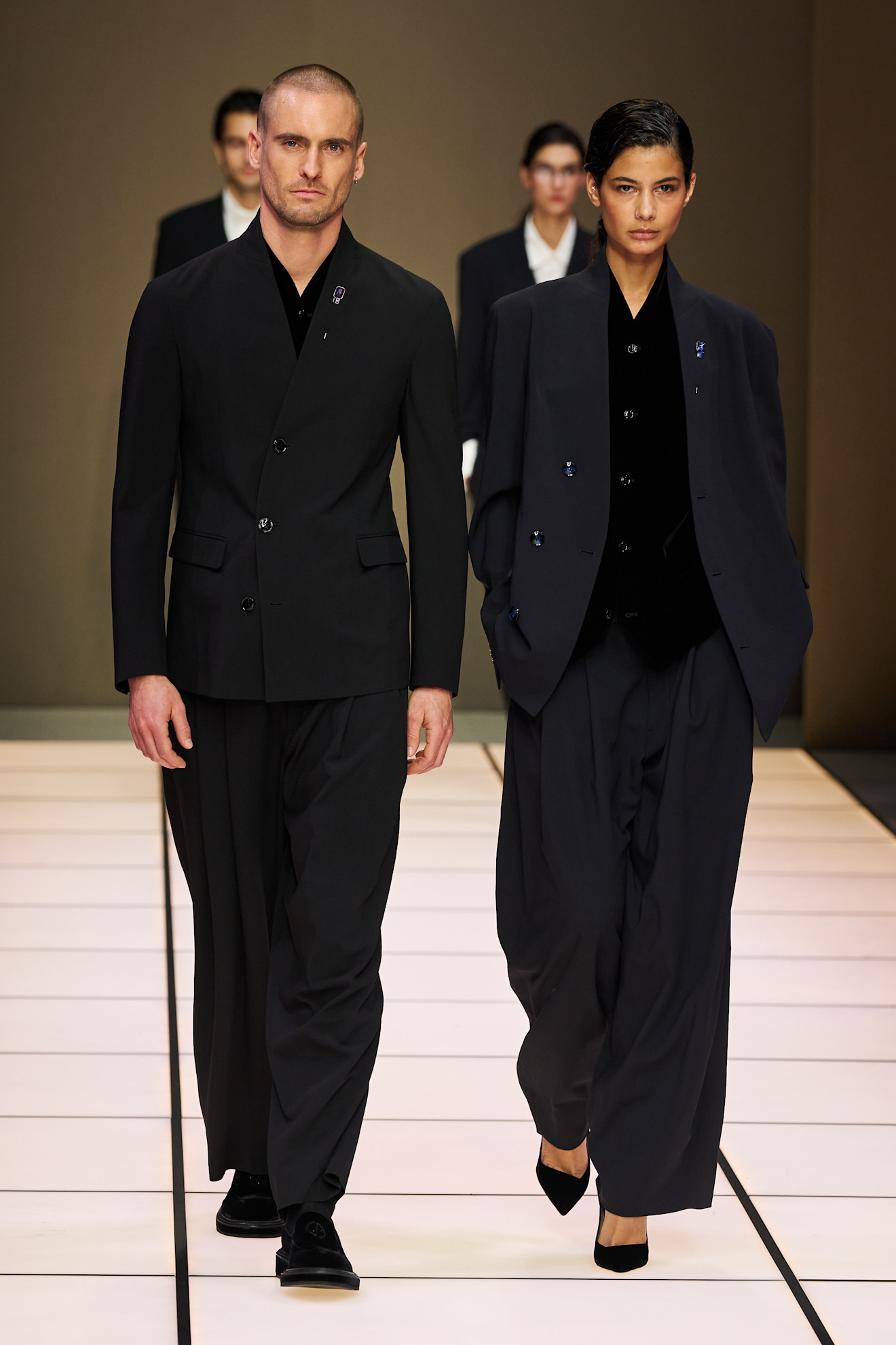 Современный дуэт в черных костюмах с акцентом на текстуру и силуэт, подчеркивающий уверенность моделей