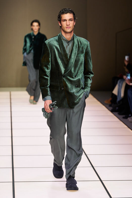 Стильный двубортный пиджак с вертикальными полосками и свободные брюки, создающие гармоничный образ в зеленых тонах