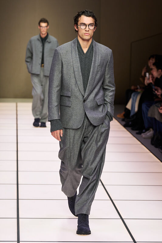 Мягкий серый пиджак в сочетании с объемными брюками и свитером, подчеркивающий современный подход к классике