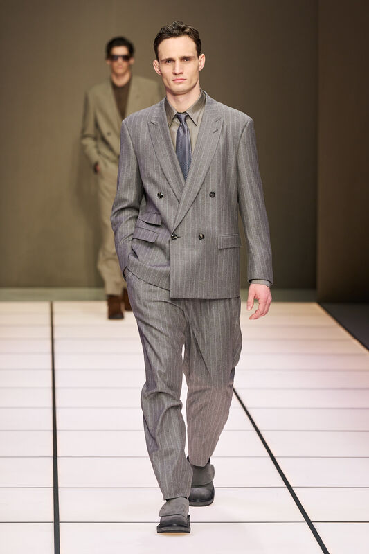 Строгий серый пиджак в полоску и классическая галстук, создают стильный деловой образ на подиуме