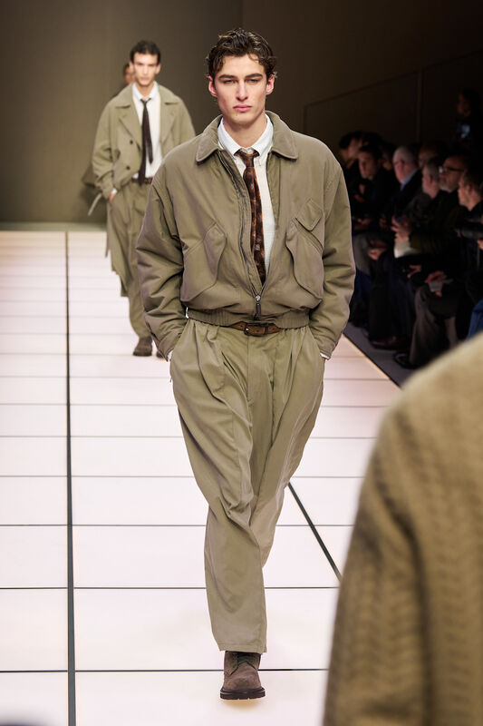 Практичный наряд с курткой и брюками в пастельных тонах, акцент на стильный галстук и уверенный взгляд модели