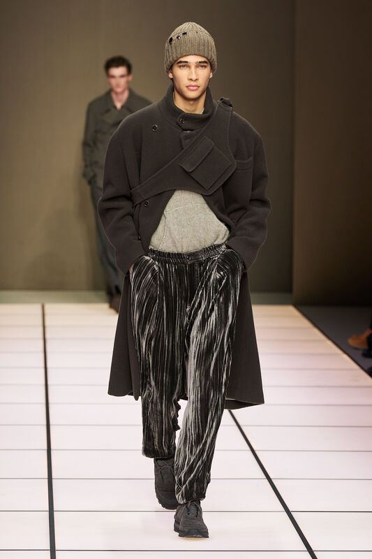 Теплый черный плащ с необычным кроем и полосатыми брюками, создающими эффект динамики и современности