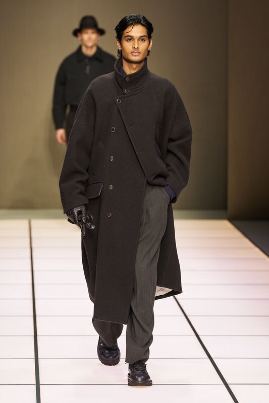 Объемное пальто в темно-сером цвете с двойной застежкой, гармонирующее с классическими брюками и кожаными перчатками