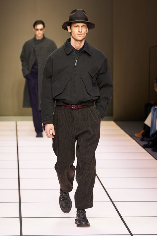 Стильный черный жакет с широкими карманами и брюки с узором, дополненные элегантной шляпой для завершения образа