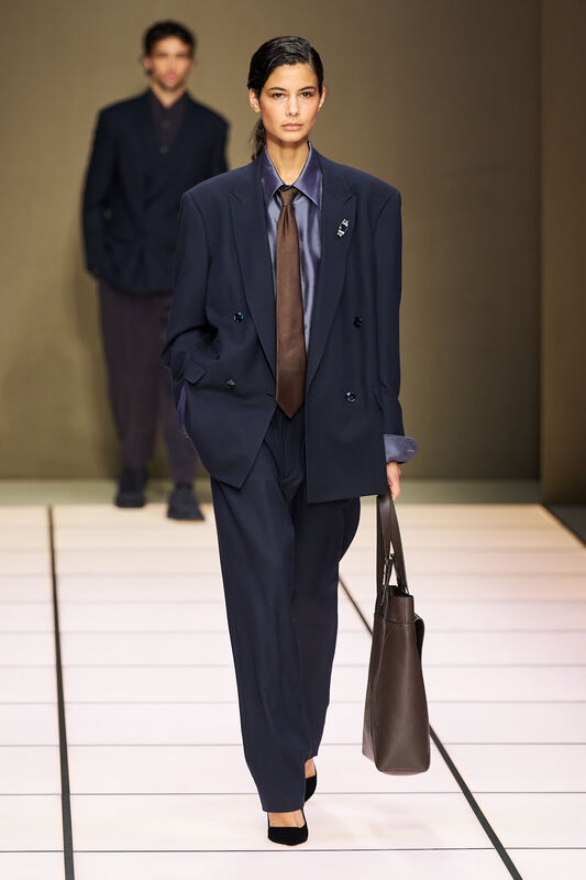 Элегантный женский костюм с объемным пиджаком и коричневым галстуком, подчеркивающий силуэт и стиль