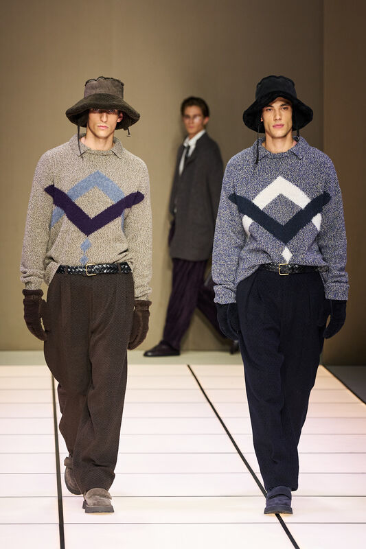 Два модели в уютных свитерах с геометрическим узором, дополненных широкими брюками и шляпами, создают атмосферу осеннего уюта