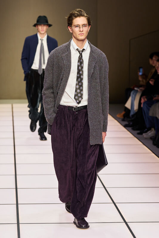 Стильный образ с объемным кардиганом и бархатными брюками, дополненный галстуком с оригинальным принтом, подчеркивает элегантность