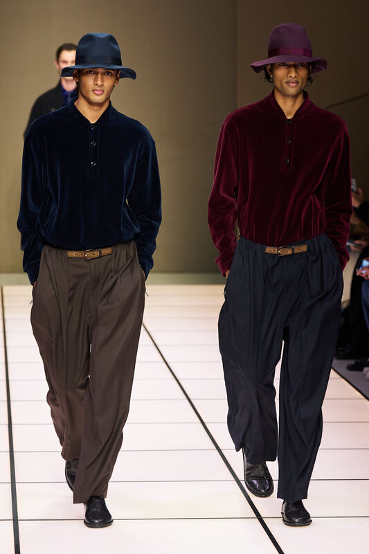 Два мужчины в бархатных футболках глубоких оттенков, с широкими брюками и стильными шляпами, создают атмосферу уюта