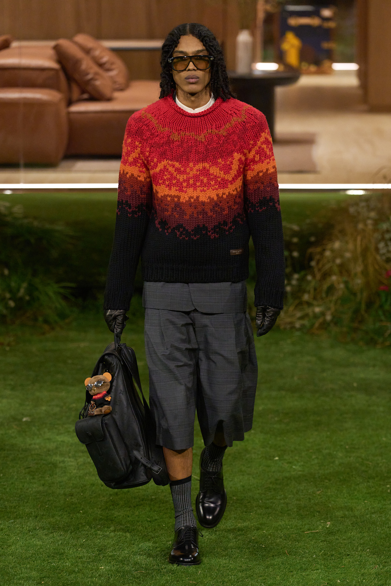 Свитер с градиентом в теплых тонах, шорты и черные ботинки, создают расслабленный и модный образ