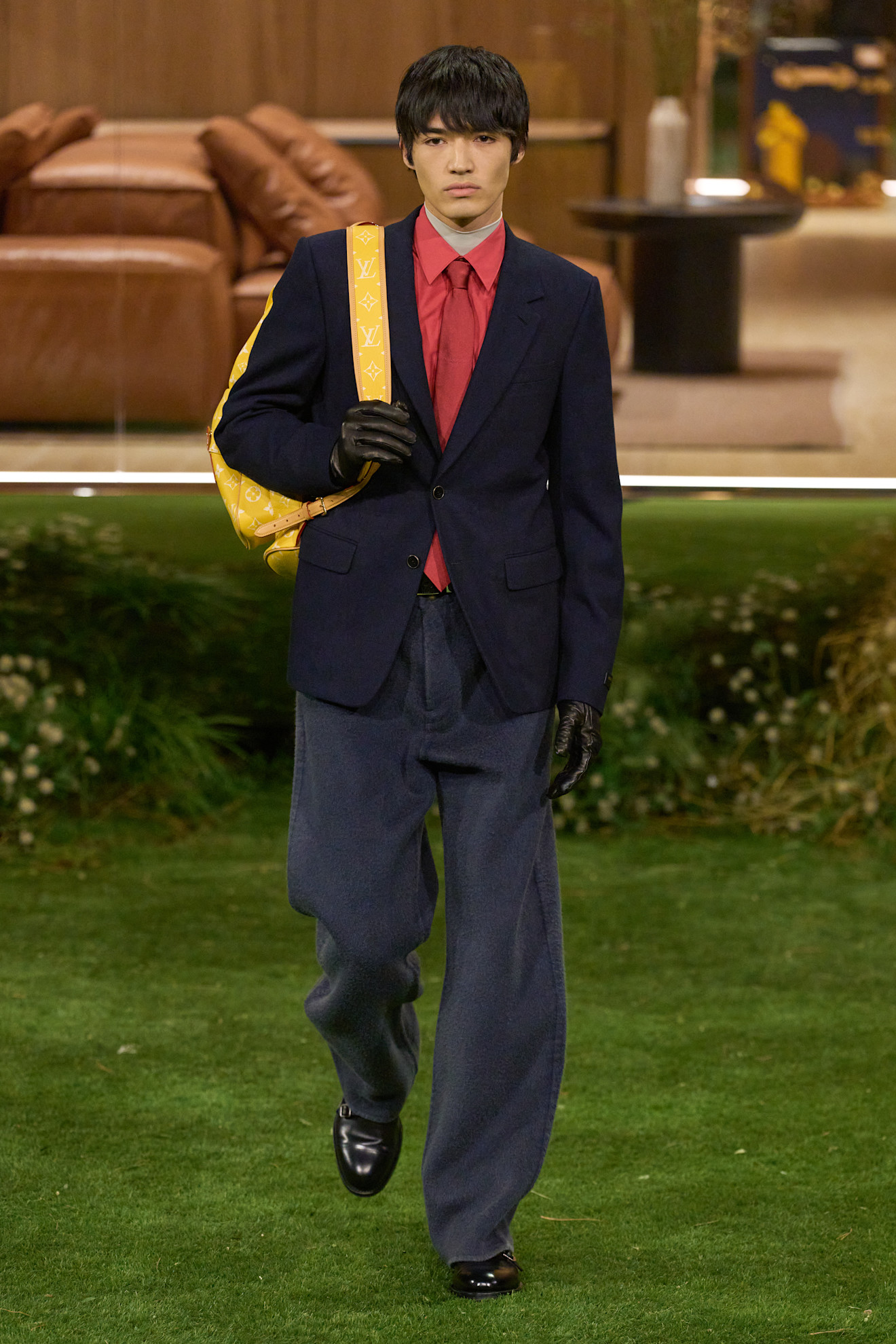 Темно-синий пиджак с яркой рубашкой и широкими брюками, акцент на желтой сумке добавляет яркости образу