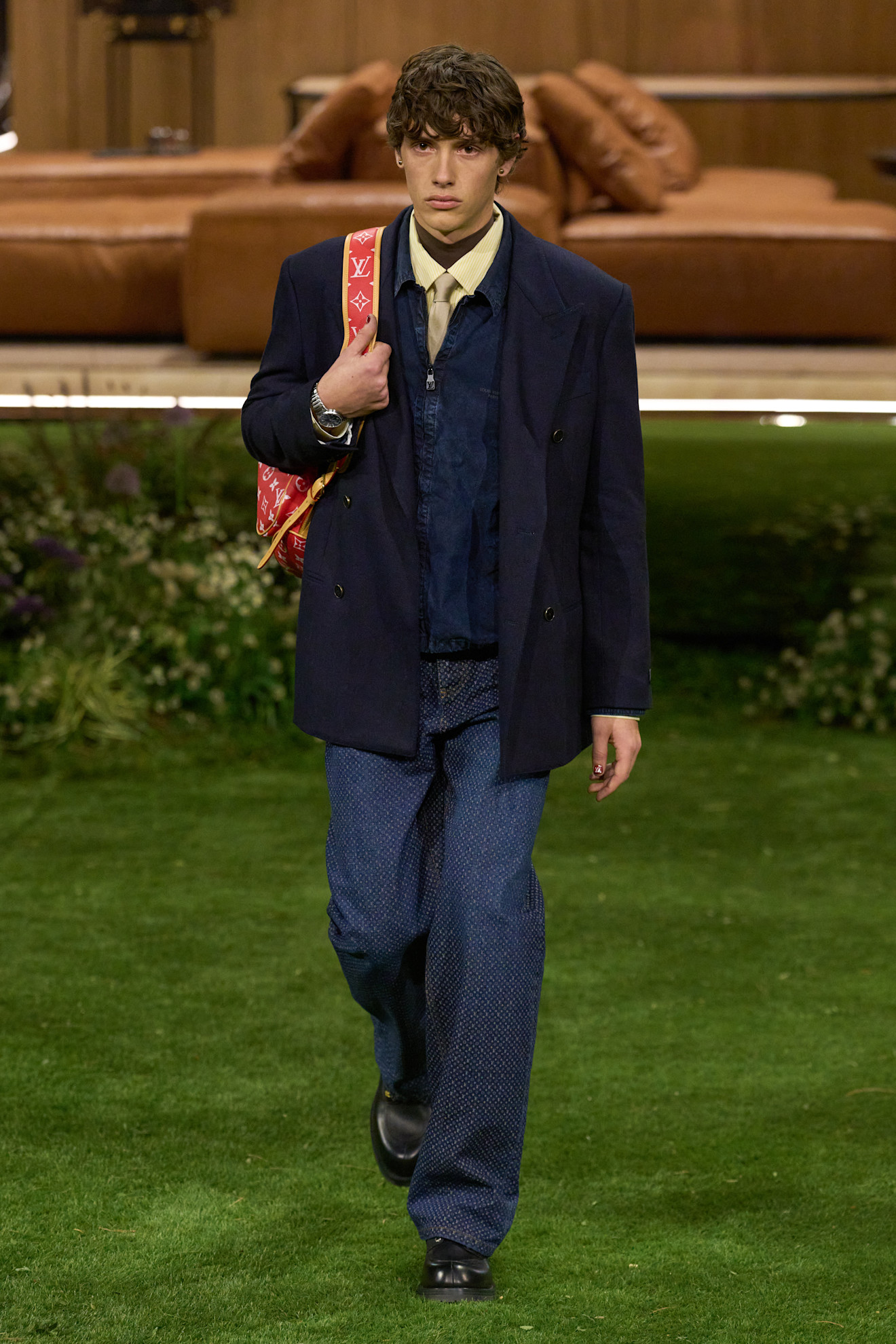 Элегантный наряд с темно-синим пиджаком и узорчатыми брюками, яркая сумка добавляет динамики в строгий образ