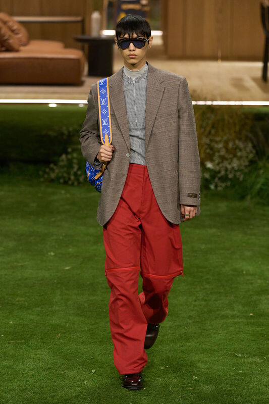Классический пиджак в клетку, яркие красные брюки и солнцезащитные очки, подчеркивают смелый стиль