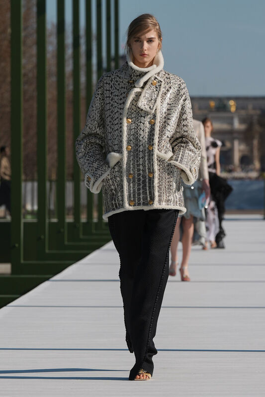 Уютный жакет с текстурой под змеиную кожу и меховой отделкой, гармонирующий с черными брюками, создает стильный контраст