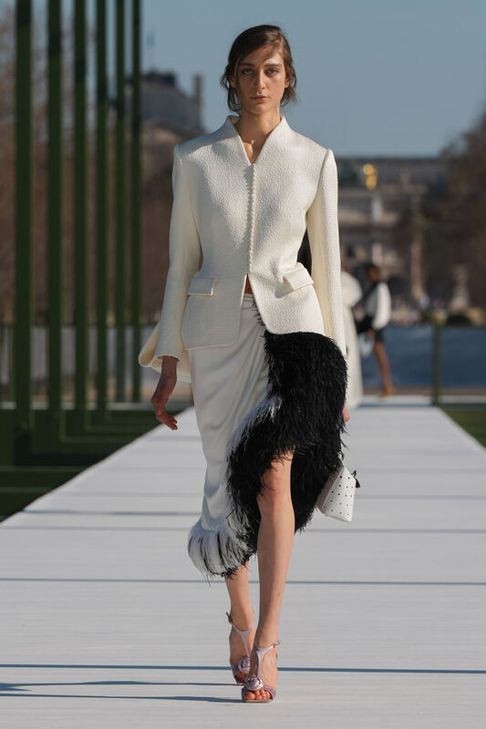 Элегантный белый жакет с текстурой и черной отделкой, сочетание строгого и игривого в образе на подиуме