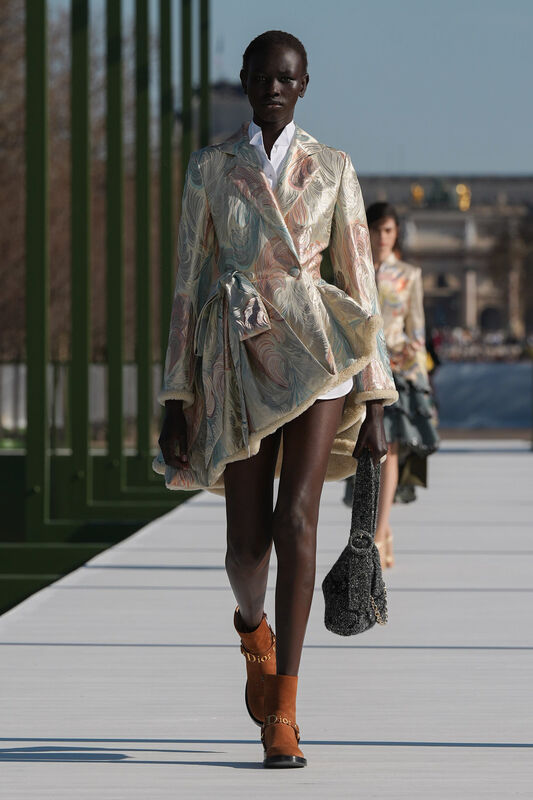 Платье с абстрактным узором в пастельных тонах и асимметричный крой создают эффектный образ, дополненный замшевыми ботинками