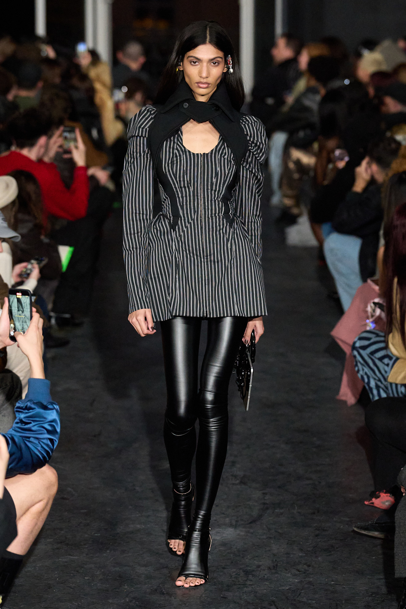 Модель в полосатом жакете с открытыми плечами и облегающих черных леггинсах, создает элегантный и современный образ