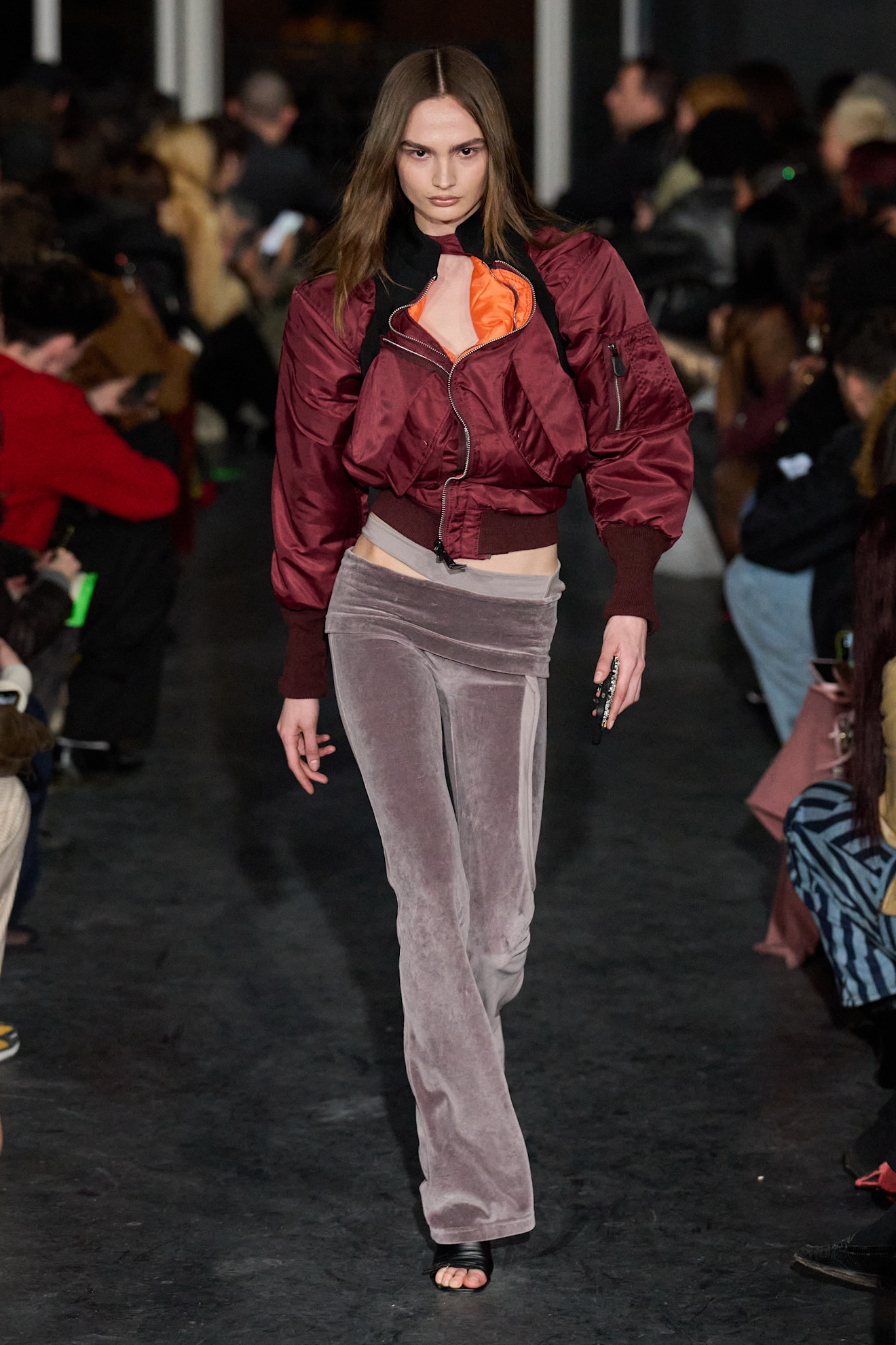 Стильный образ с бордовой курткой и светло-розовыми брюками, подчеркивающими фигуру, яркий акцент на оранжевом топе