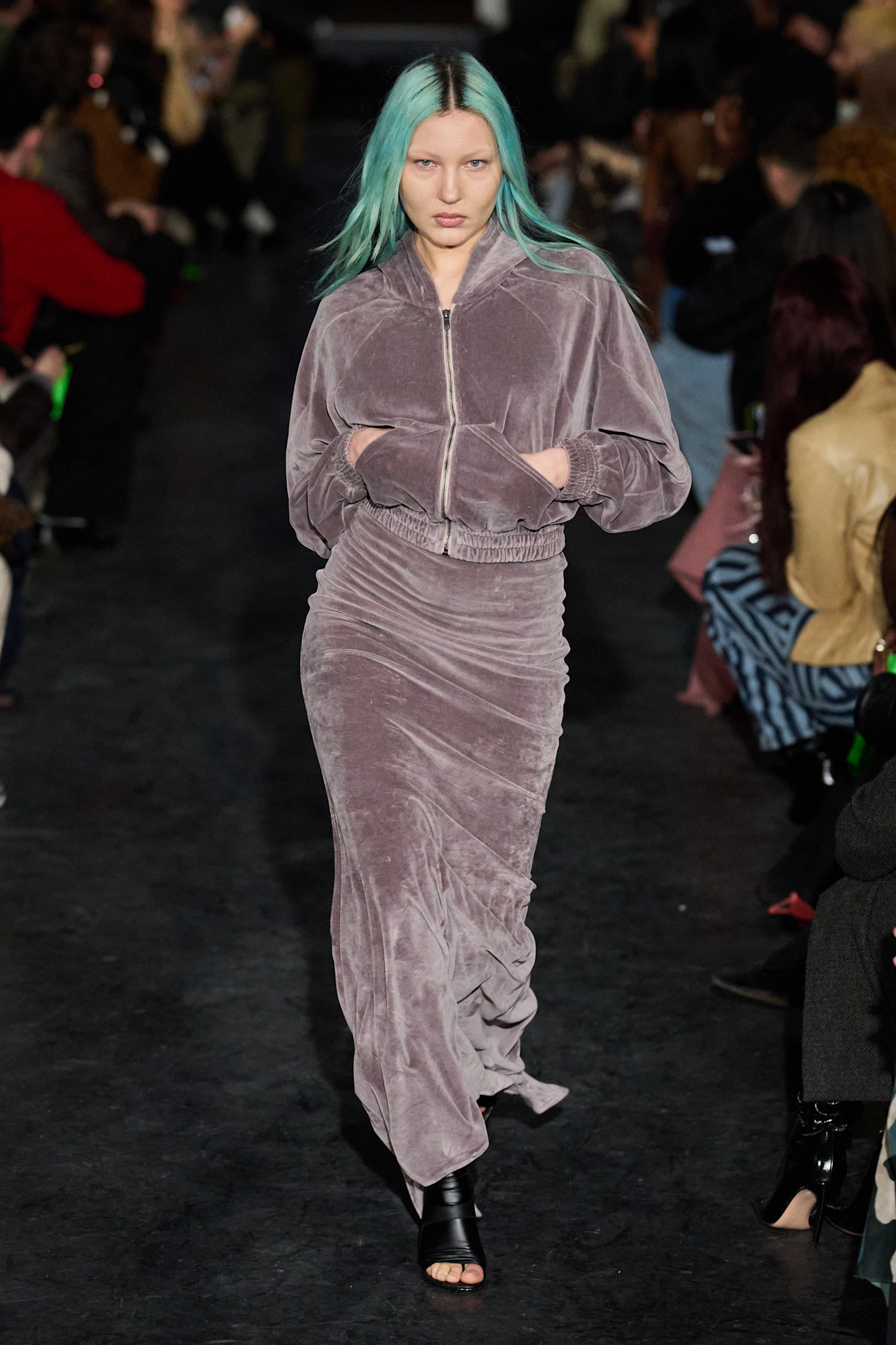 Модель в сером бархатном костюме с юбкой и худи, волосы окрашены в яркий голубой цвет