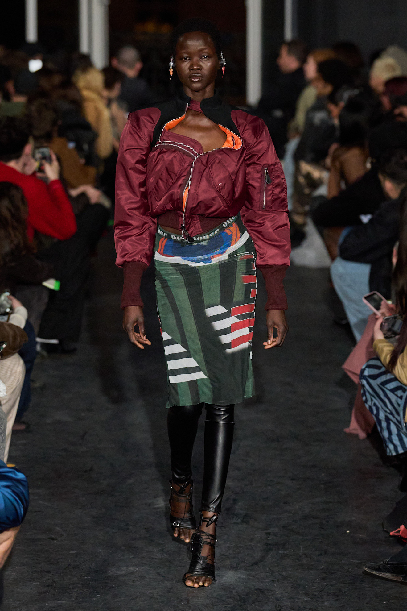 Яркий образ с бордовой курткой и юбкой с геометрическим принтом, подчеркивающей индивидуальность и смелость