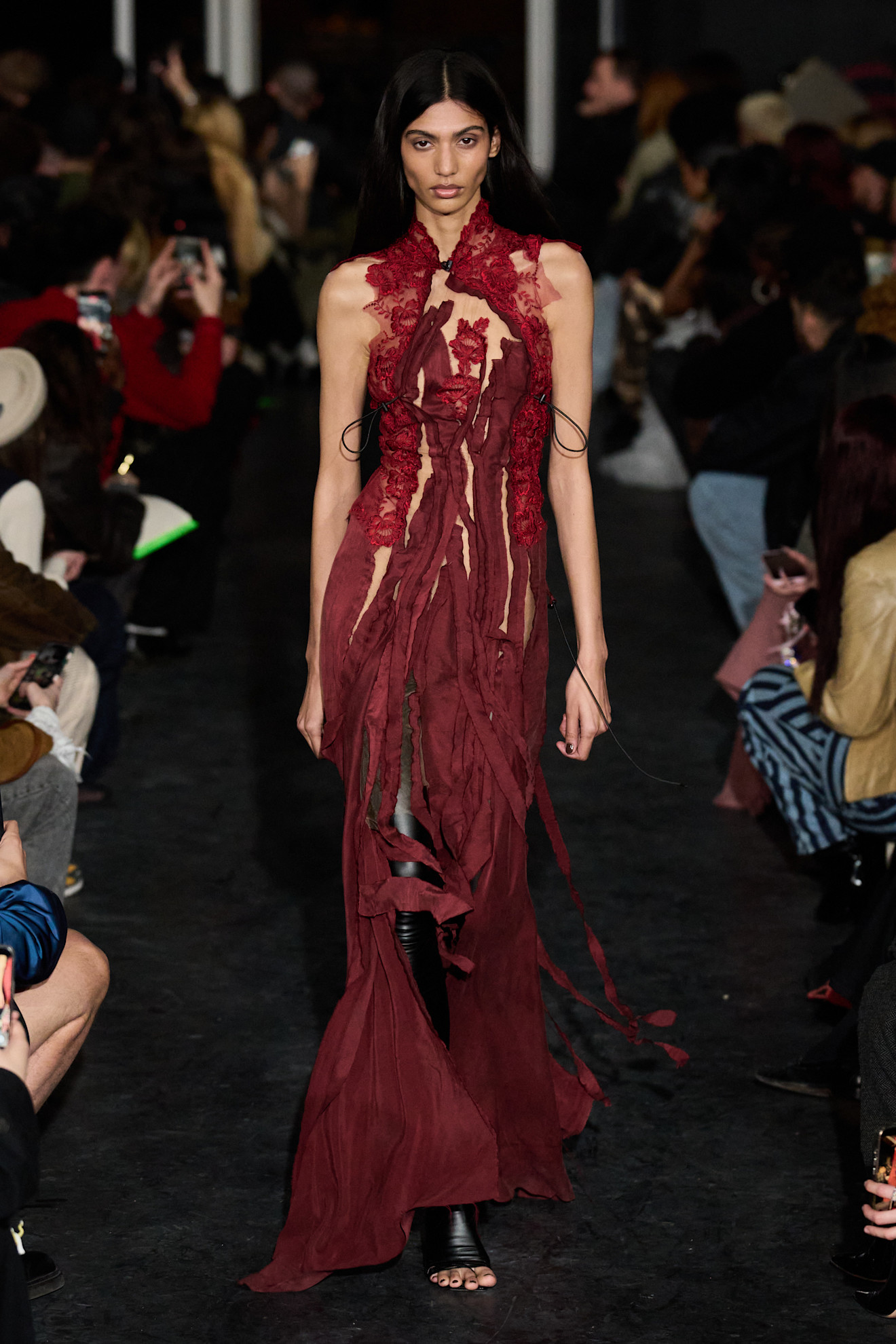 Платье в бордовом цвете с асимметричными вырезами и кружевными деталями, подчеркивающее женственность и смелость