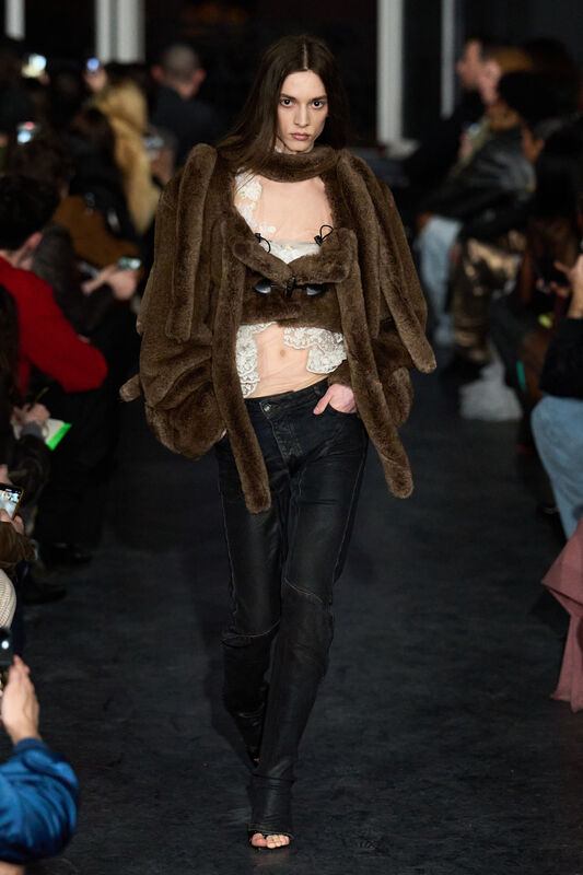 Модель в коричневом меховом пиджаке и кружевном топе, подчеркивающем женственность и элегантность