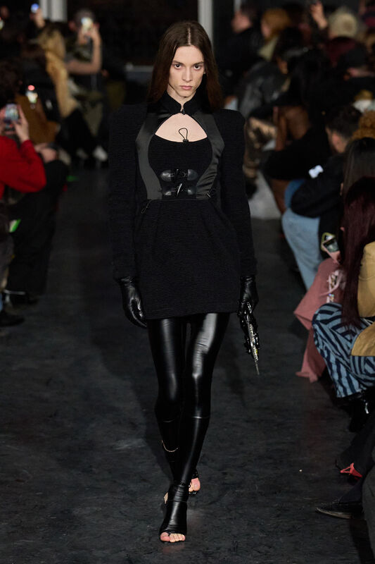 Черное платье с открытыми плечами и блестящими леггинсами, дополнено стильными перчатками и аксессуарами