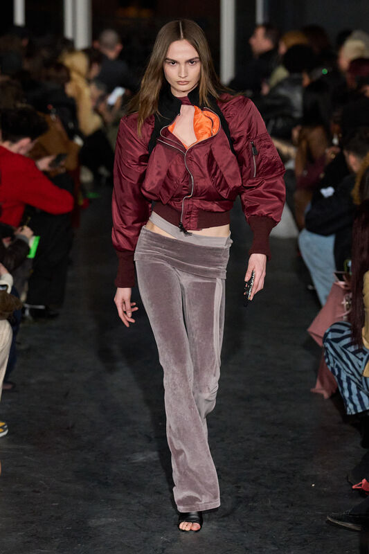 Стильный образ с бордовой курткой и светло-розовыми брюками, подчеркивающими фигуру, яркий акцент на оранжевом топе