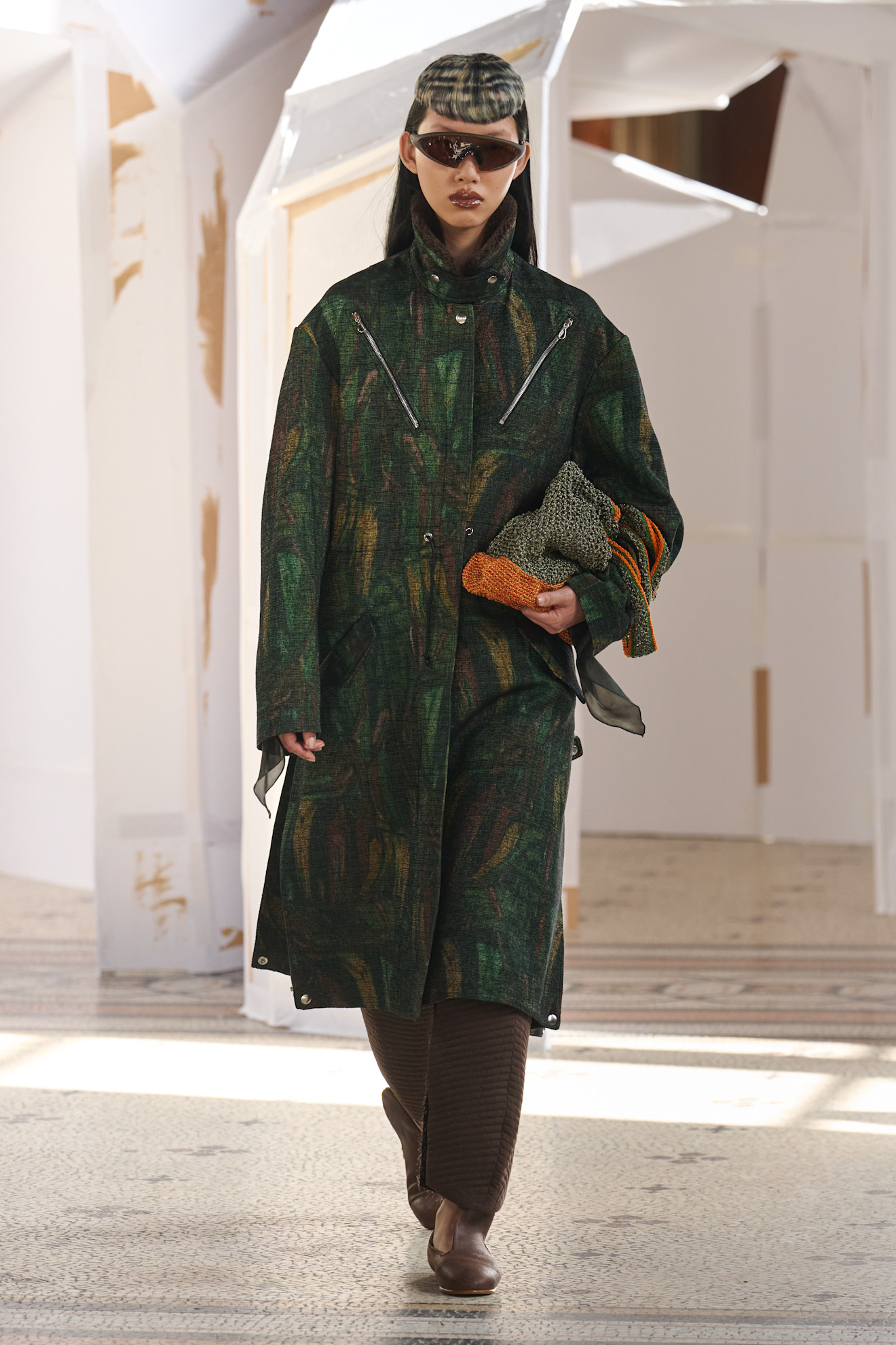 Длинное пальто с текстурой и яркими акцентами, дополненное стильными аксессуарами, создает образ уверенной и модной женщины