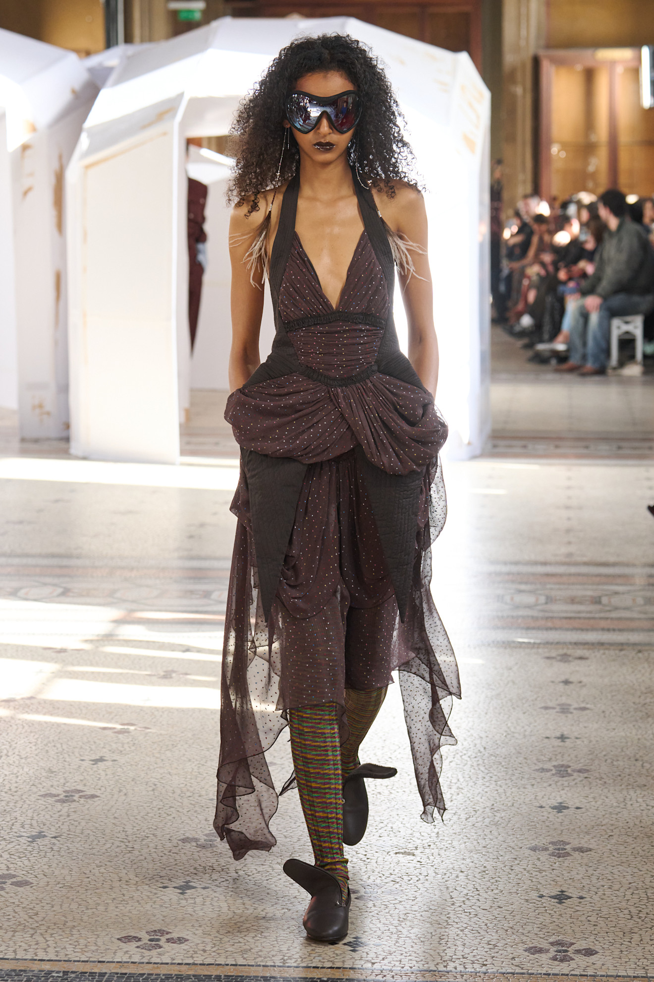 Элегантное платье с глубоким вырезом и драпировкой, дополненное яркими колготками и эффектными очками