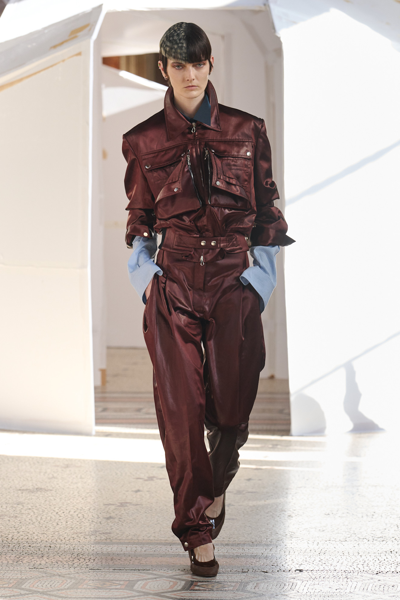 Лаконичный комбинезон бордового цвета с объемными карманами и контрастными рукавами, подчеркивающий силуэт модели