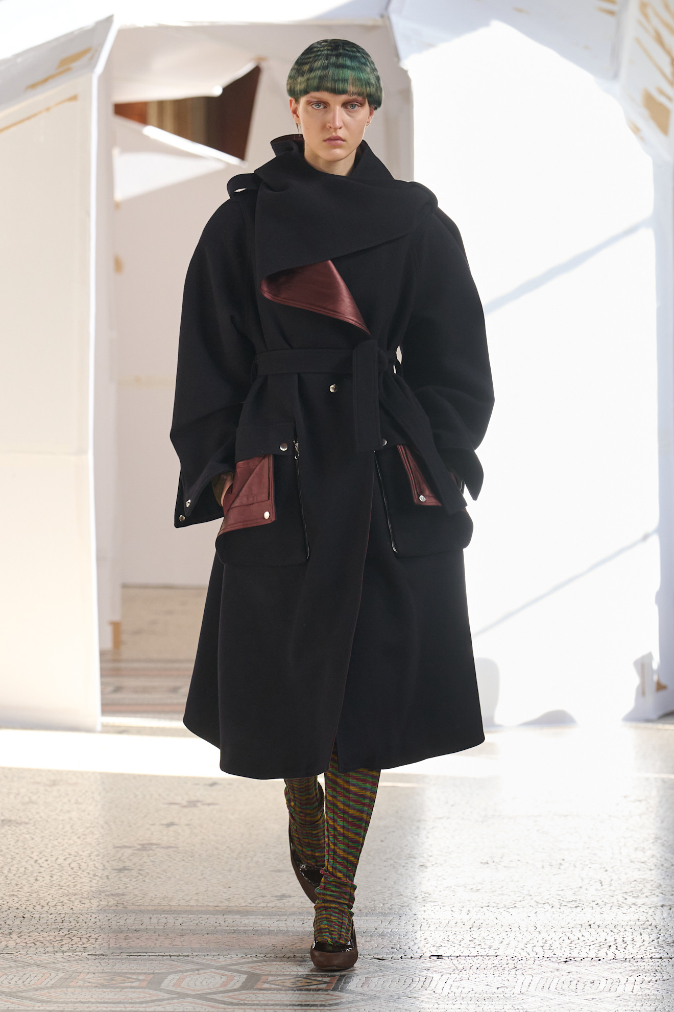 Элегантный черный плащ с бордовыми деталями и крупными карманами, подчеркивающий утонченность образа