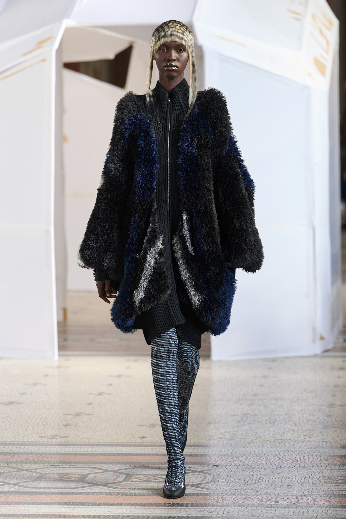 Объемный меховой пальто с контрастными вставками, сочетание текстур и узоров, подчеркивающее элегантность