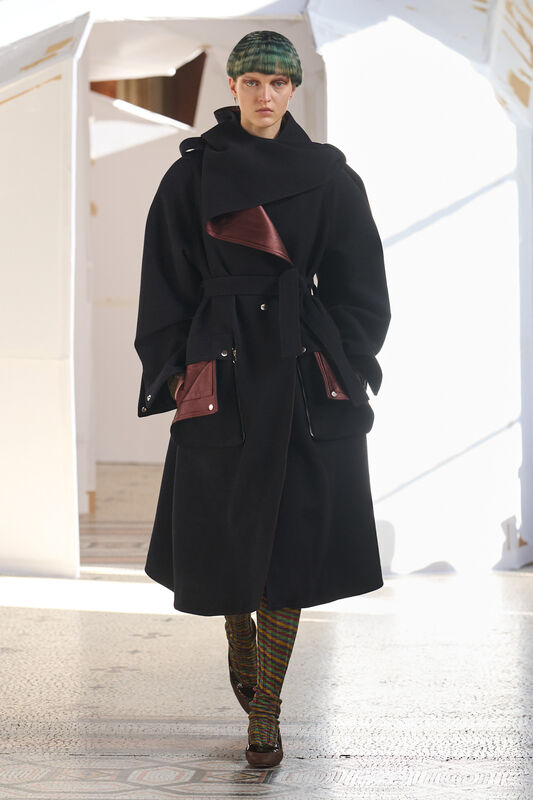 Элегантный черный плащ с бордовыми деталями и крупными карманами, подчеркивающий утонченность образа