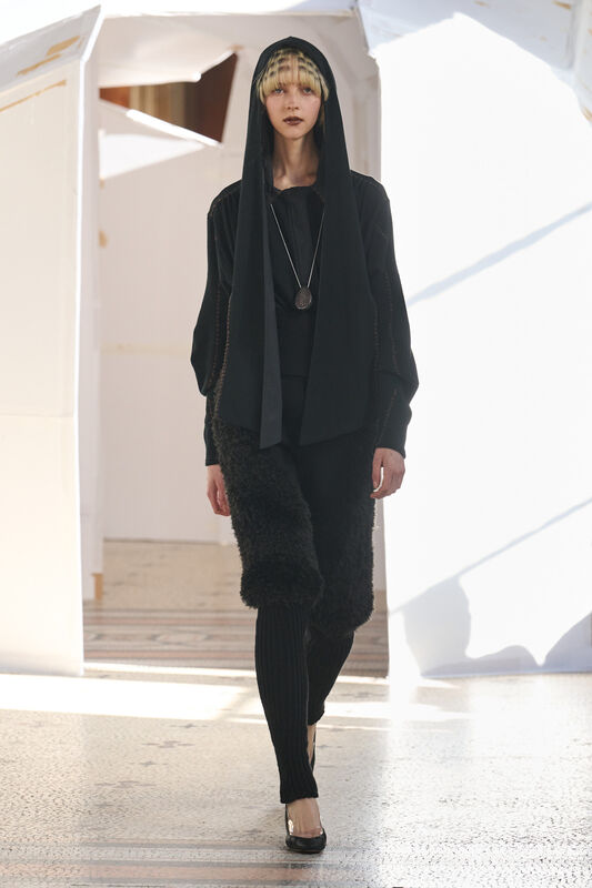 Черный наряд с капюшоном и фактурными элементами, создающий загадочную атмосферу