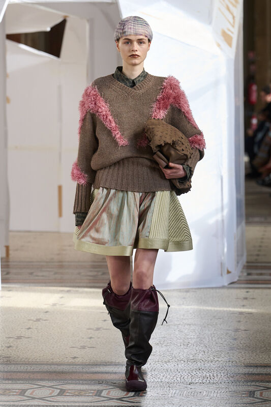 Свитер с пушистыми деталями и юбка с текстурой в сочетании с высокими сапогами создают уютный осенний образ.