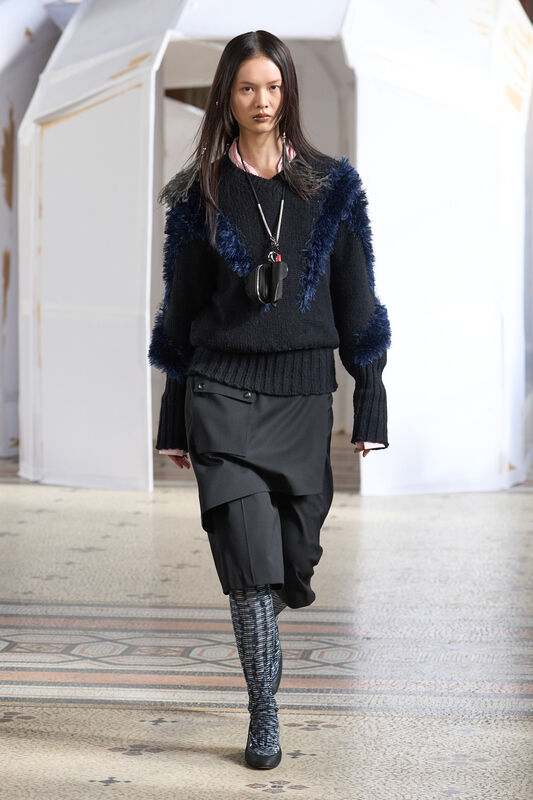Уютный черный свитер с пушистыми вставками, комбинированный с многослойной юбкой и стильными ботфортами