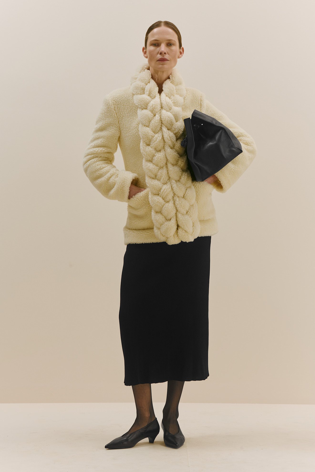 Уютный кремовый жакет с объемным воротником и черной юбкой, акцент на текстуре и контрасте с сумкой