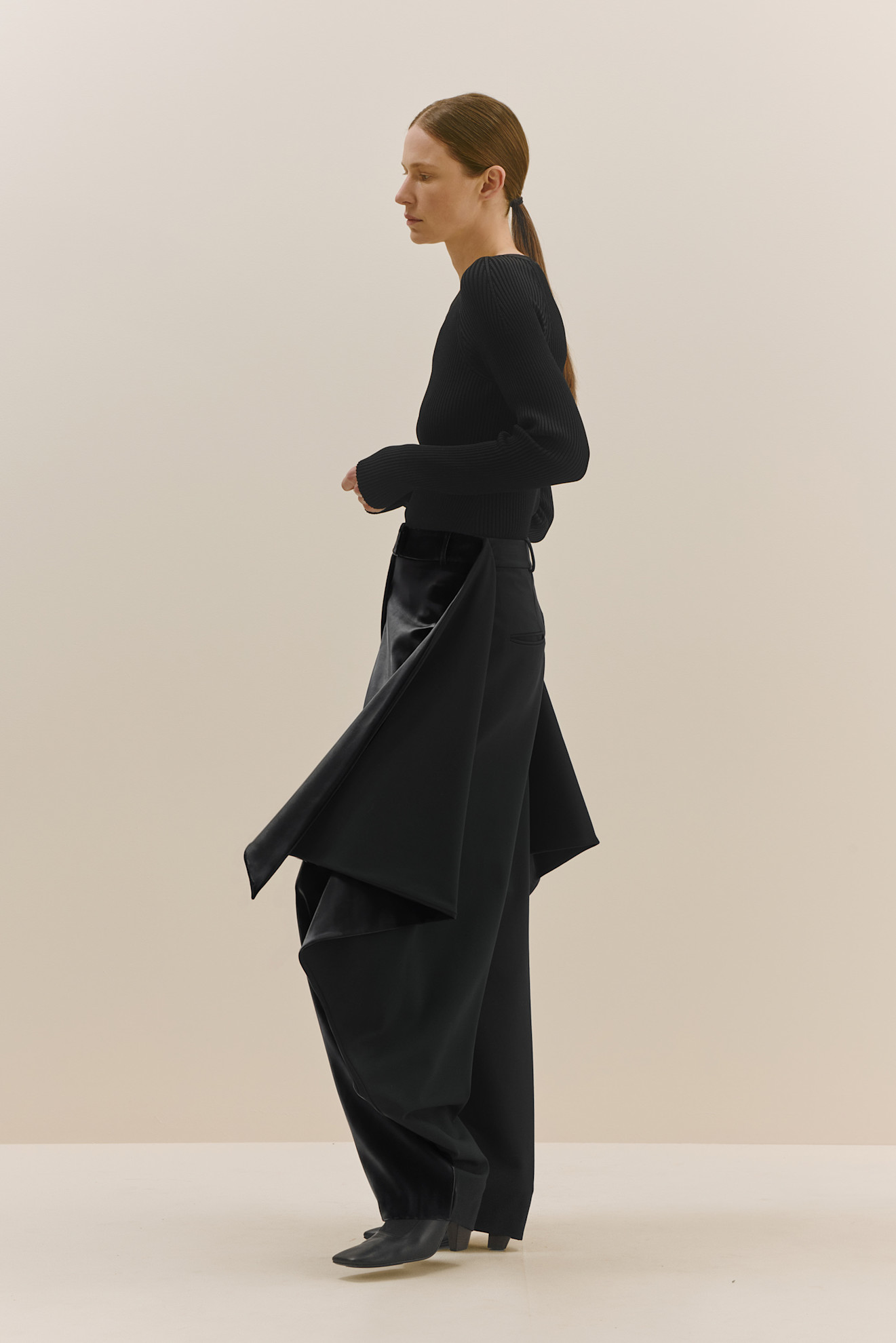 Стильный черный наряд с асимметричными брюками, подчеркивающими силуэт, и облегающим верхом